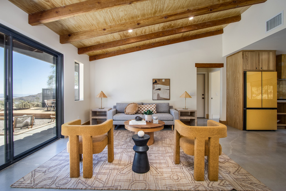Свежая идея для дизайна: гостиная комната в стиле фьюжн с бежевыми стенами, бетонным полом, угловым камином, фасадом камина из плитки, серым полом и деревянным потолком - отличное фото интерьера