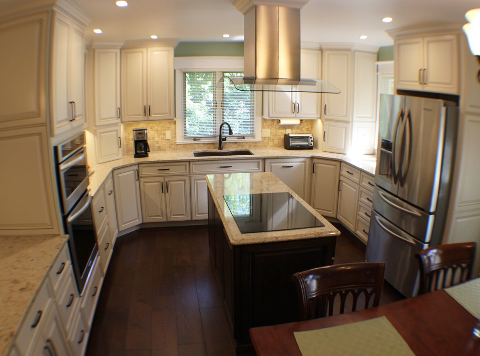 Mid-sized traditional u-shaped eat-in kitchen in Chicago with an undermount sink, raised-panel cabinets, white cabinets, quartz benchtops, beige splashback, stone tile splashback, stainless steel appliances, medium hardwood floors and with island.