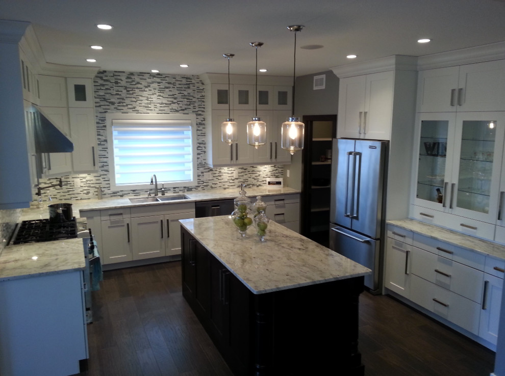 Inspiration for a mid-sized transitional u-shaped medium tone wood floor enclosed kitchen remodel with an undermount sink, shaker cabinets, white cabinets, granite countertops, multicolored backsplash, matchstick tile backsplash, stainless steel appliances and an island