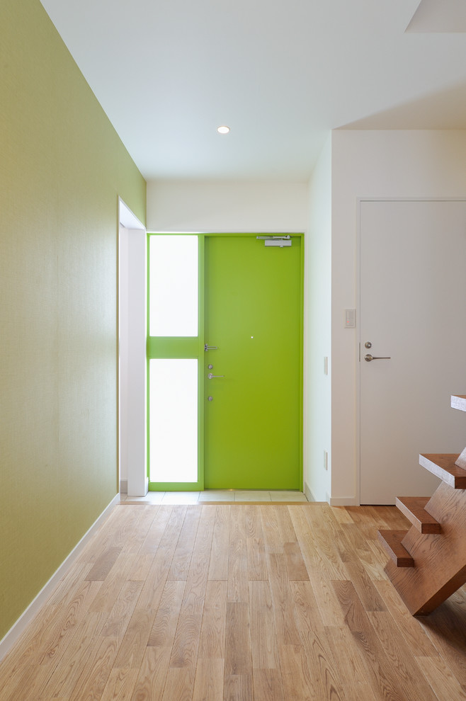 Design ideas for a mid-sized modern entry hall in Tokyo with multi-coloured walls, medium hardwood floors, a single front door, a green front door and beige floor.