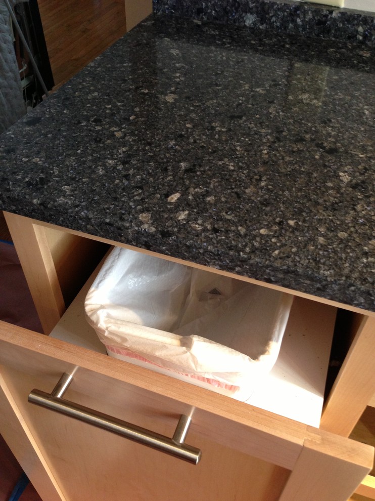 Inspiration for a small transitional u-shaped medium tone wood floor enclosed kitchen remodel in Chicago with a double-bowl sink, shaker cabinets, light wood cabinets, quartzite countertops, stainless steel appliances and a peninsula