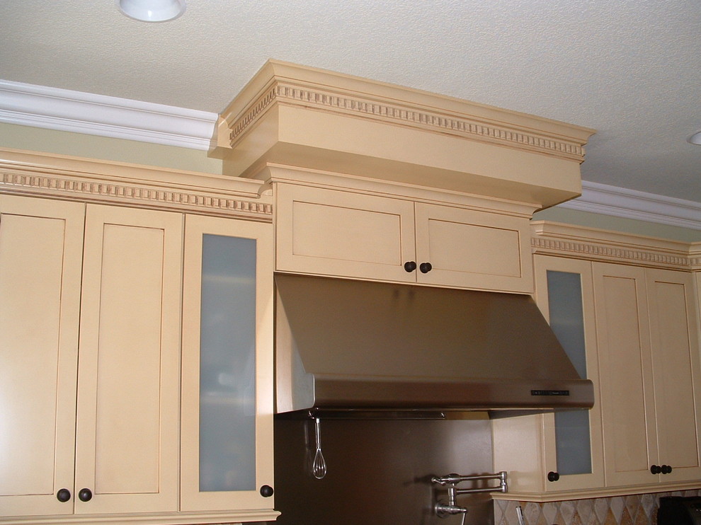 Eat-in kitchen - mid-sized transitional u-shaped travertine floor eat-in kitchen idea in Orange County with a farmhouse sink, shaker cabinets, yellow cabinets, quartz countertops, multicolored backsplash, stone tile backsplash, stainless steel appliances and an island
