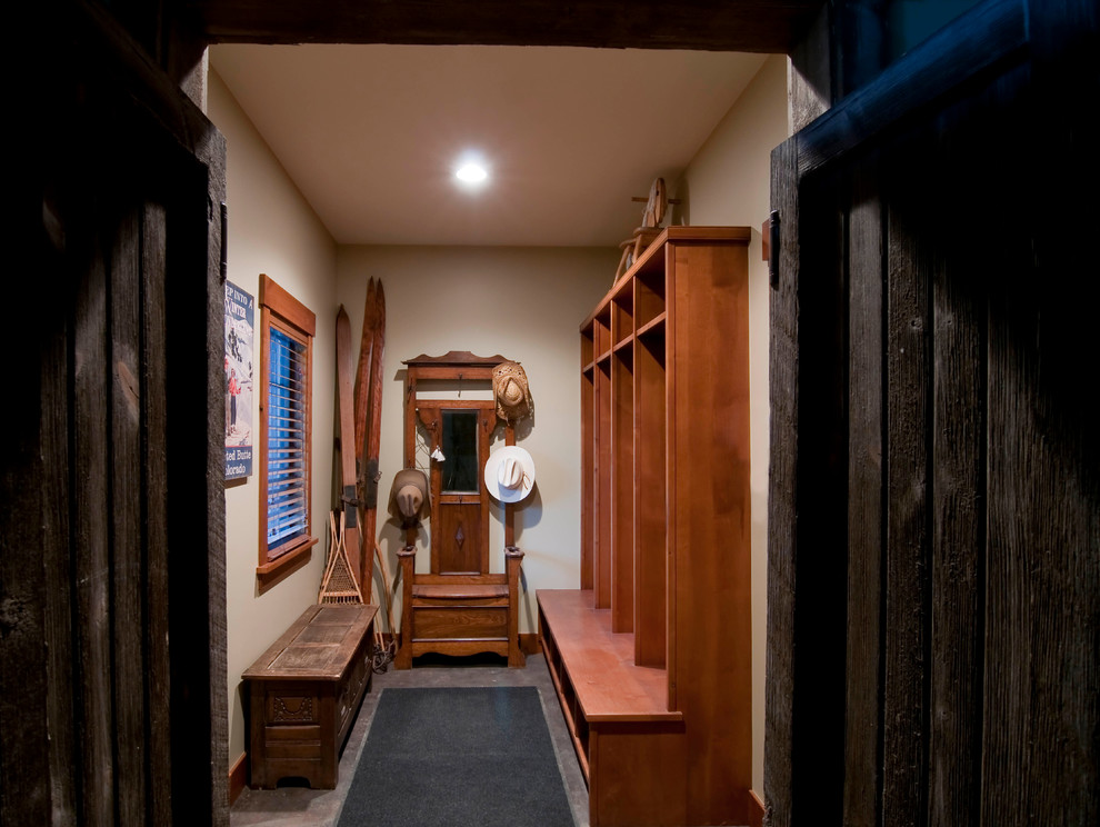 Mudroom - rustic gender-neutral concrete floor mudroom idea in Denver with open cabinets, medium tone wood cabinets and beige walls