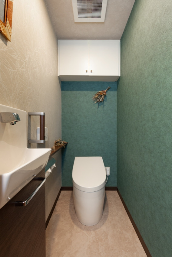 Cette photo montre un WC et toilettes moderne avec WC à poser, un mur vert, un sol beige, un plafond en papier peint et du papier peint.