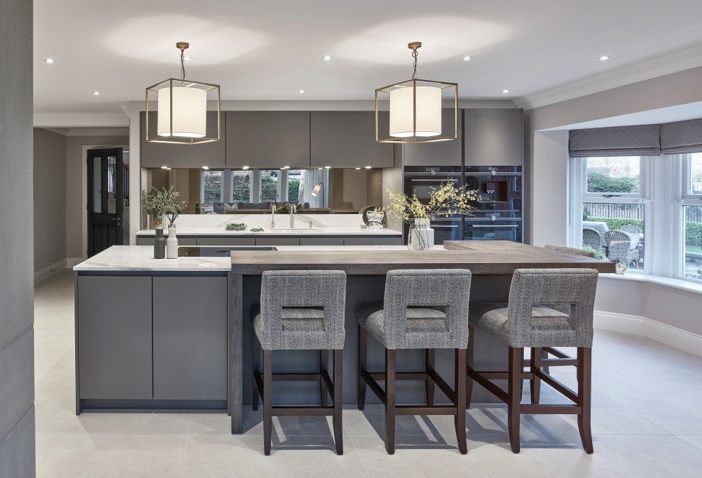 Large contemporary galley kitchen in Other with an undermount sink, flat-panel cabinets, grey cabinets, mirror splashback, panelled appliances, porcelain floors, with island, grey floor and white benchtop.
