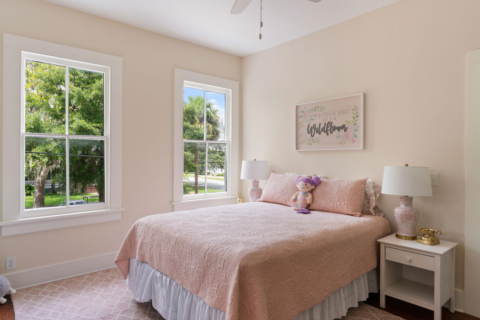Immagine di una camera da letto tradizionale di medie dimensioni con pareti rosa, pavimento in legno massello medio, camino classico, cornice del camino in legno e pavimento marrone