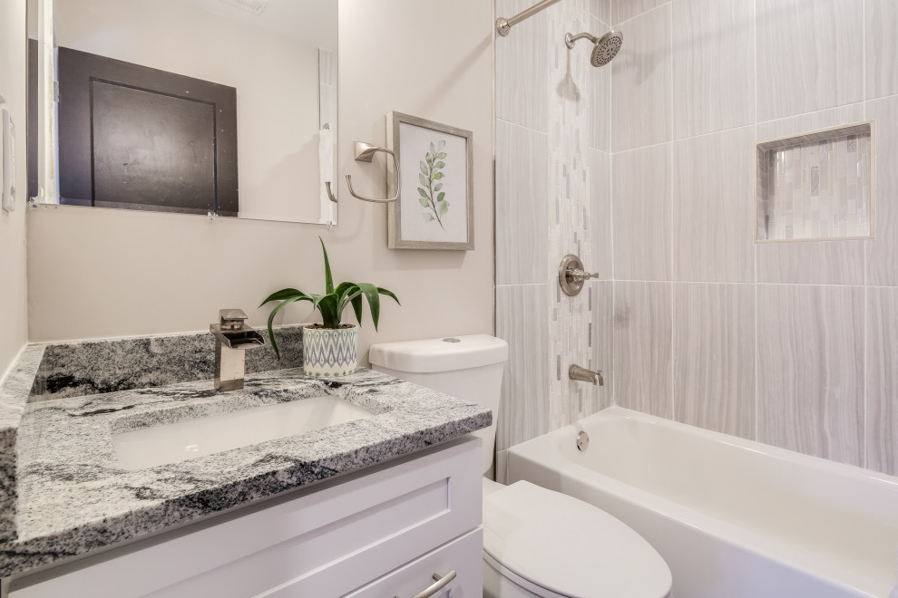 This is an example of a mid-sized traditional 3/4 bathroom in Baltimore with beige walls, laminate floors, multi-coloured floor, shaker cabinets, white cabinets, a corner tub, an alcove shower, beige tile, ceramic tile, a drop-in sink, granite benchtops, a shower curtain, grey benchtops, a single vanity and a built-in vanity.