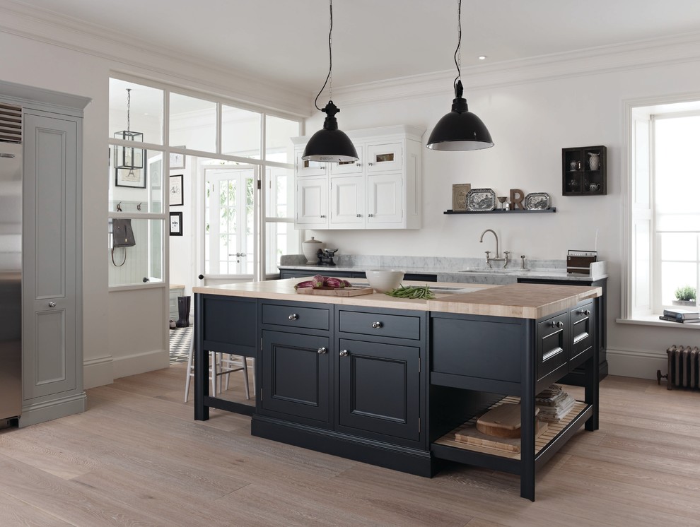 Inspiration for a transitional separate kitchen in Manchester with a single-bowl sink, recessed-panel cabinets, white cabinets, marble benchtops, light hardwood floors, with island and grey benchtop.