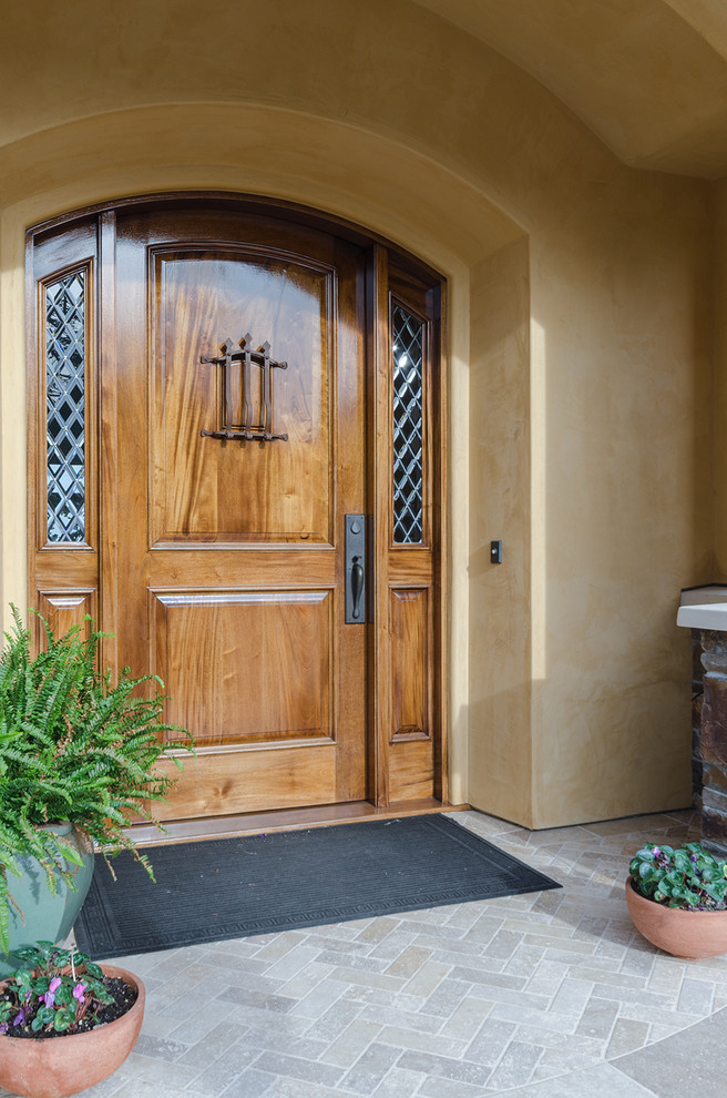 Photo of a mediterranean entryway in San Francisco with yellow walls, a single front door and a medium wood front door.