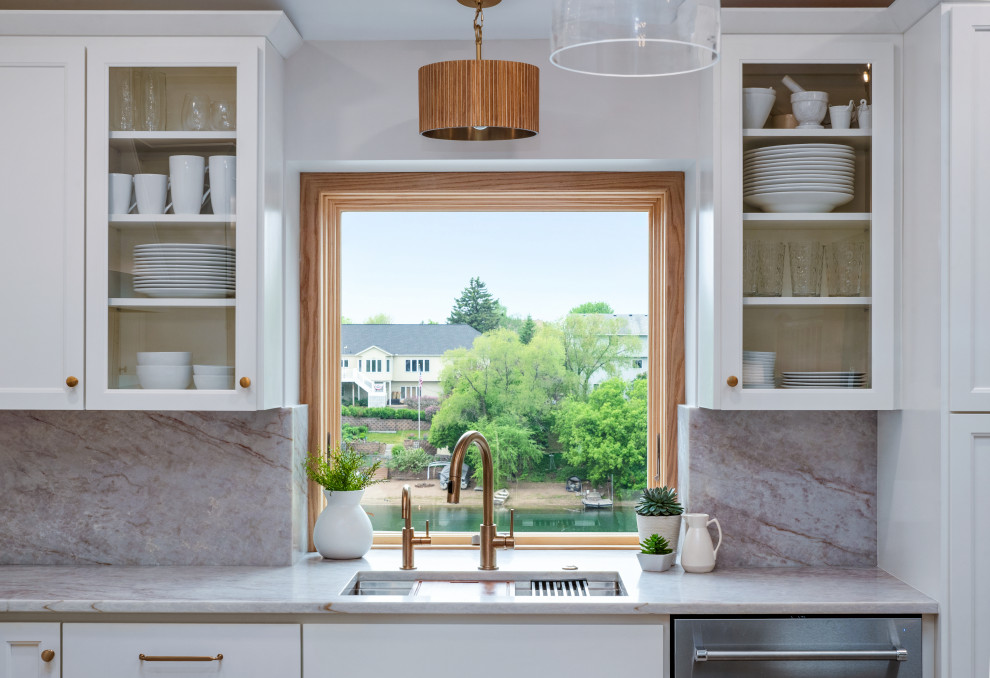 Transitional vaulted ceiling kitchen photo in Minneapolis with white cabinets, an island and white countertops