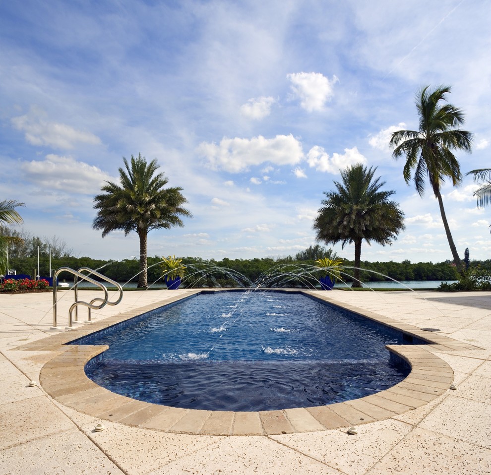 Inspiration for a large mediterranean backyard custom-shaped natural pool in Tampa with a water feature.