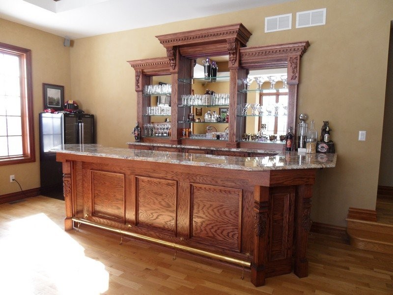 Design ideas for a mid-sized traditional single-wall seated home bar in New York with a drop-in sink, recessed-panel cabinets, dark wood cabinets, granite benchtops and medium hardwood floors.