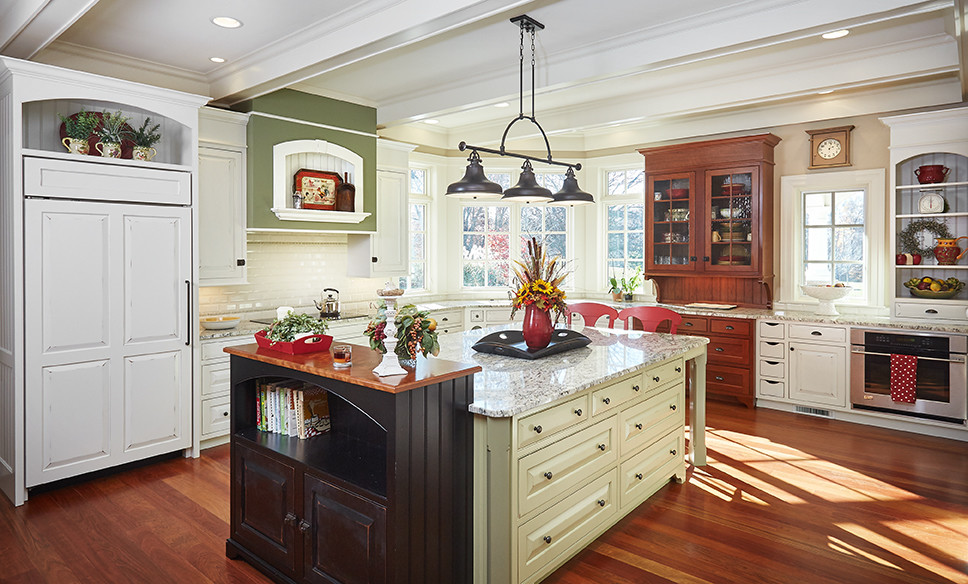 Example of a classic kitchen design in Grand Rapids with quartz countertops, white backsplash, subway tile backsplash, paneled appliances and an island