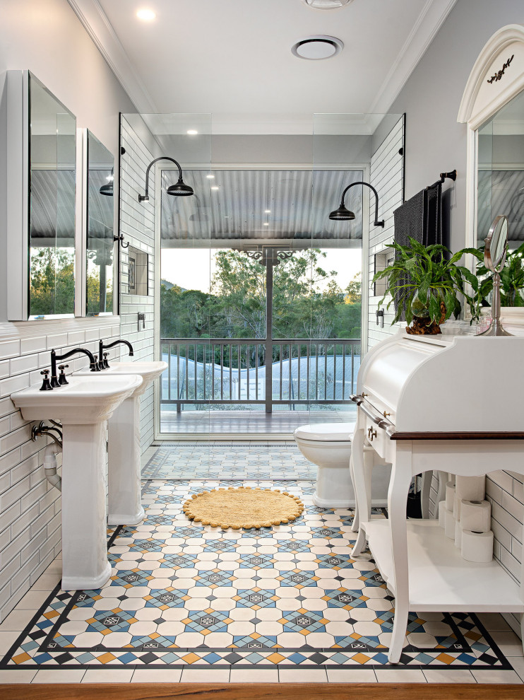 This is an example of a small country ensuite bathroom in Brisbane with a claw-foot bath, a corner shower, a one-piece toilet, white tiles, metro tiles, grey walls, mosaic tile flooring, a hinged door, a wall niche, a single sink and a freestanding vanity unit.