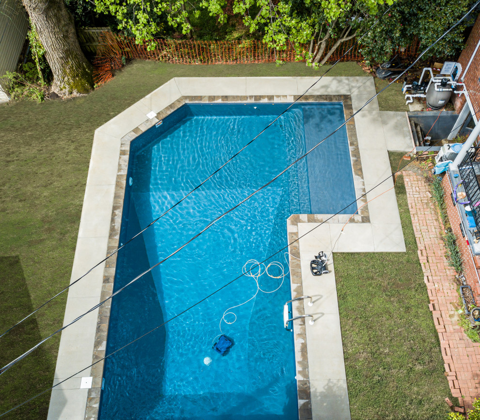 На фото: большой естественный ландшафтный бассейн произвольной формы на заднем дворе в стиле модернизм с покрытием из бетонных плит
