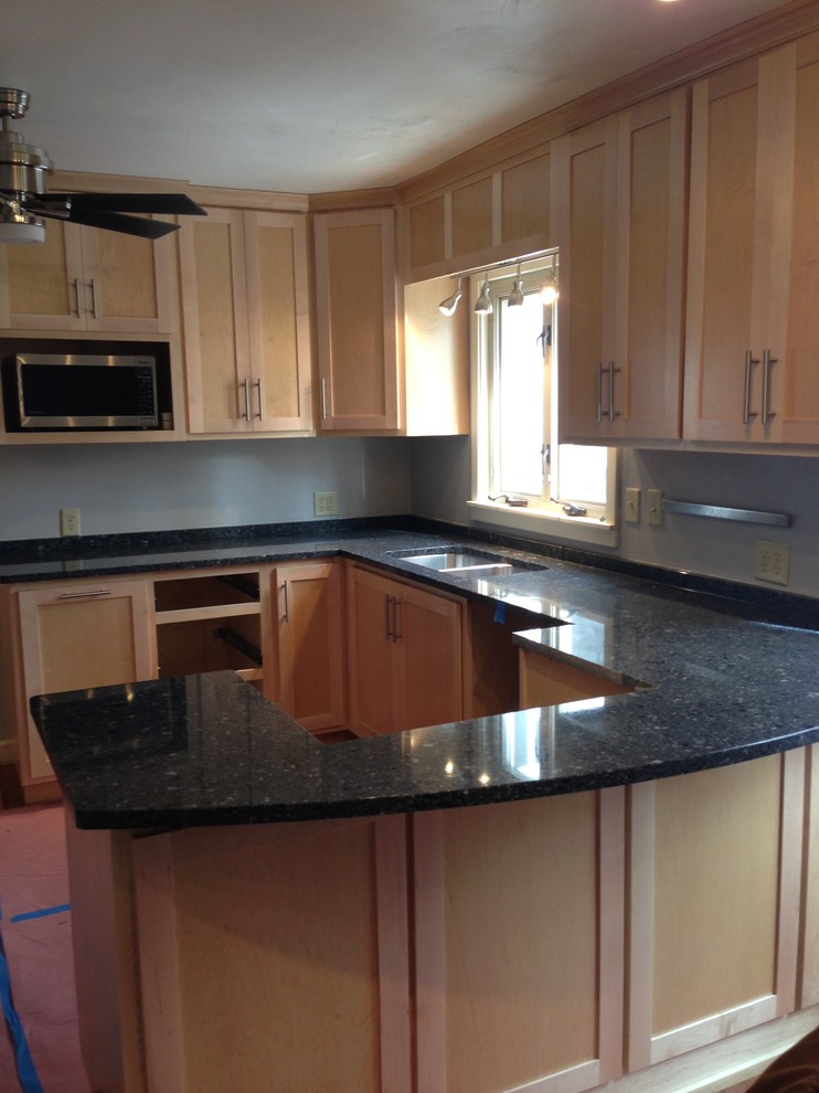 Small transitional u-shaped medium tone wood floor enclosed kitchen photo in Chicago with a double-bowl sink, shaker cabinets, light wood cabinets, quartzite countertops, stainless steel appliances and a peninsula