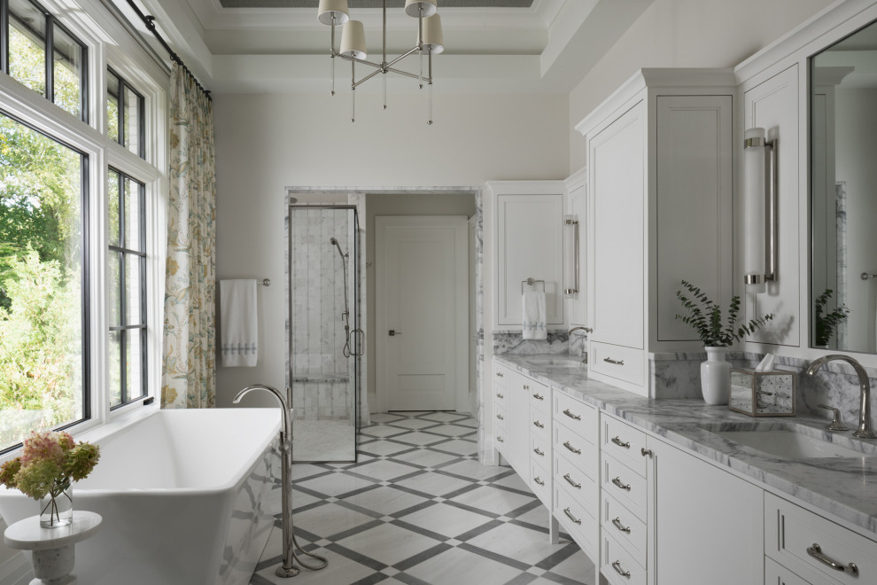 Lantlig inredning av ett grå grått en-suite badrum, med luckor med infälld panel, vita skåp, ett fristående badkar, en hörndusch, grå kakel, marmorkakel, vita väggar, klinkergolv i keramik, bänkskiva i kvartsit, vitt golv, dusch med gångjärnsdörr och ett undermonterad handfat