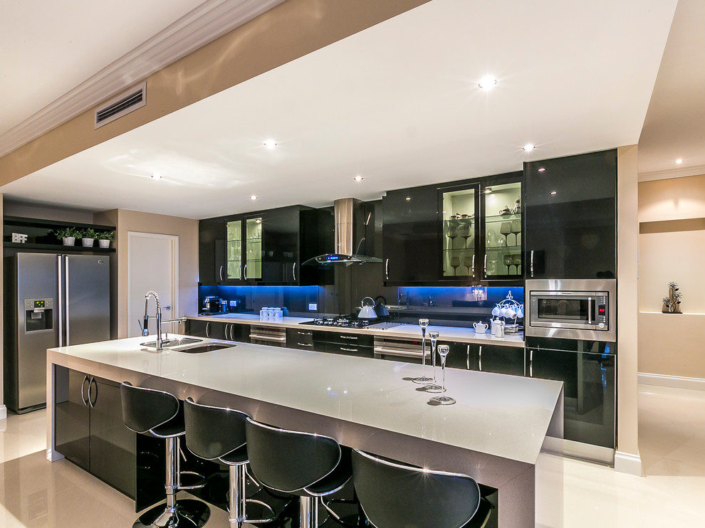 Photo of a large contemporary galley kitchen pantry in Perth with an undermount sink, black cabinets, quartz benchtops, black splashback, glass sheet splashback, stainless steel appliances, porcelain floors and with island.