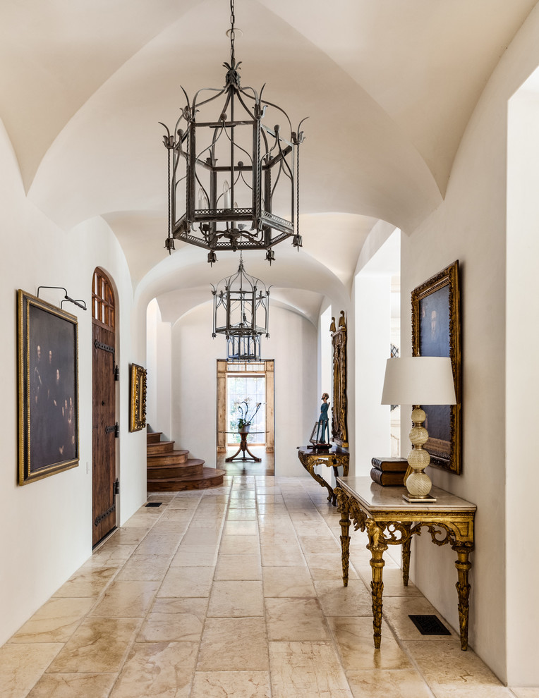 Design ideas for a mediterranean foyer in Dallas with white walls, a single front door and a dark wood front door.