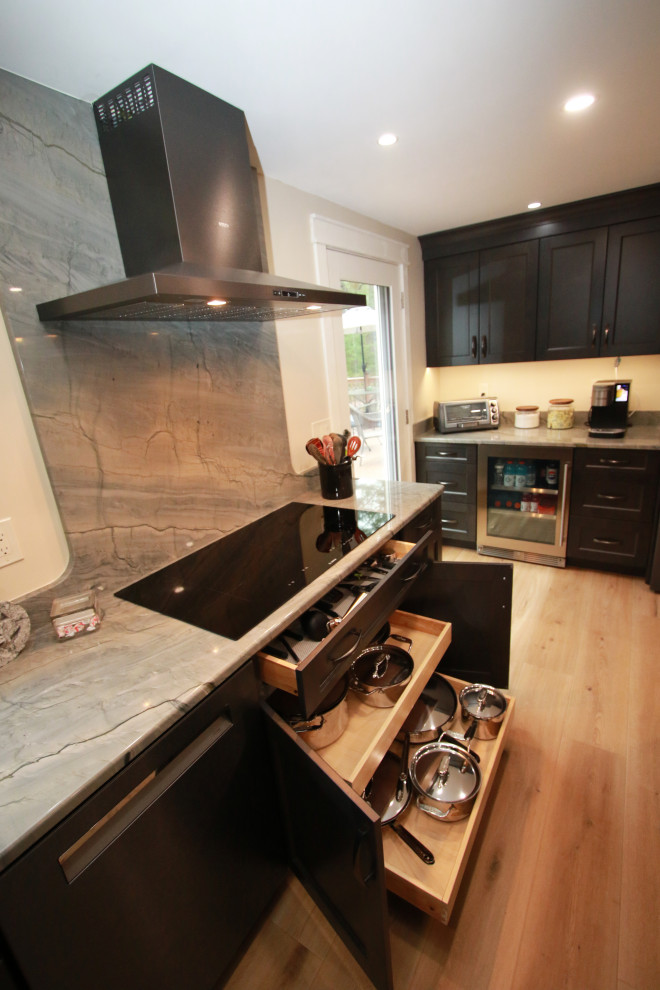 Example of a mid-sized transitional u-shaped laminate floor and brown floor eat-in kitchen design in Boston with an undermount sink, shaker cabinets, brown cabinets, quartz countertops, black appliances, an island and multicolored countertops