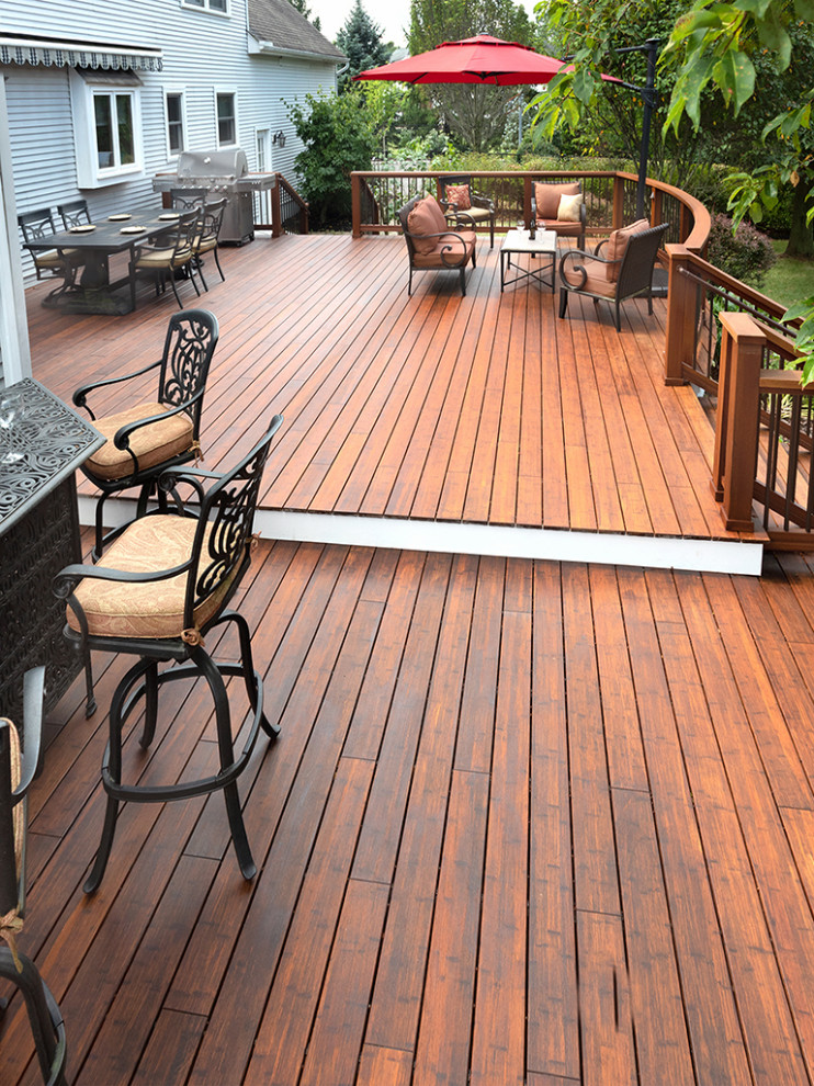 Large transitional backyard deck photo with an awning
