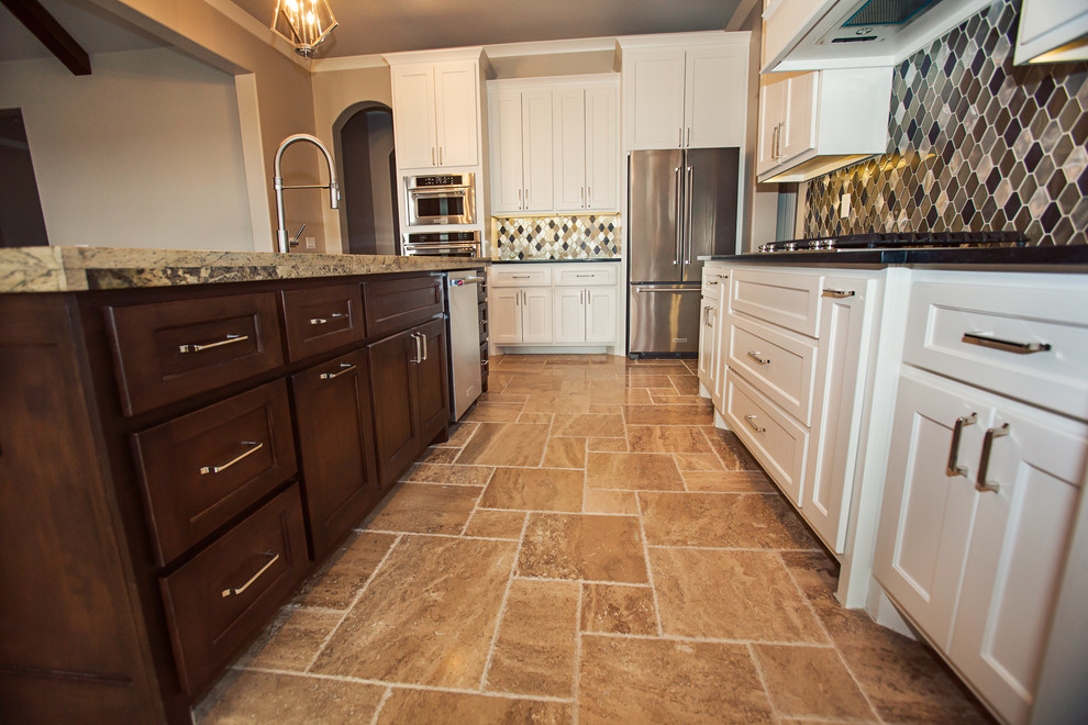 Example of a mid-sized transitional l-shaped ceramic tile open concept kitchen design with an undermount sink, shaker cabinets, white cabinets, granite countertops, multicolored backsplash, glass tile backsplash, stainless steel appliances and an island