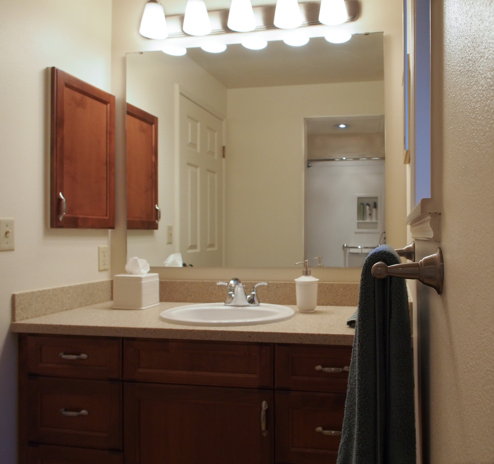 Example of a mid-sized transitional 3/4 beige tile linoleum floor, brown floor and single-sink alcove bathtub design in Seattle with a drop-in sink, recessed-panel cabinets, dark wood cabinets, solid surface countertops, a two-piece toilet, white walls, beige countertops and a built-in vanity