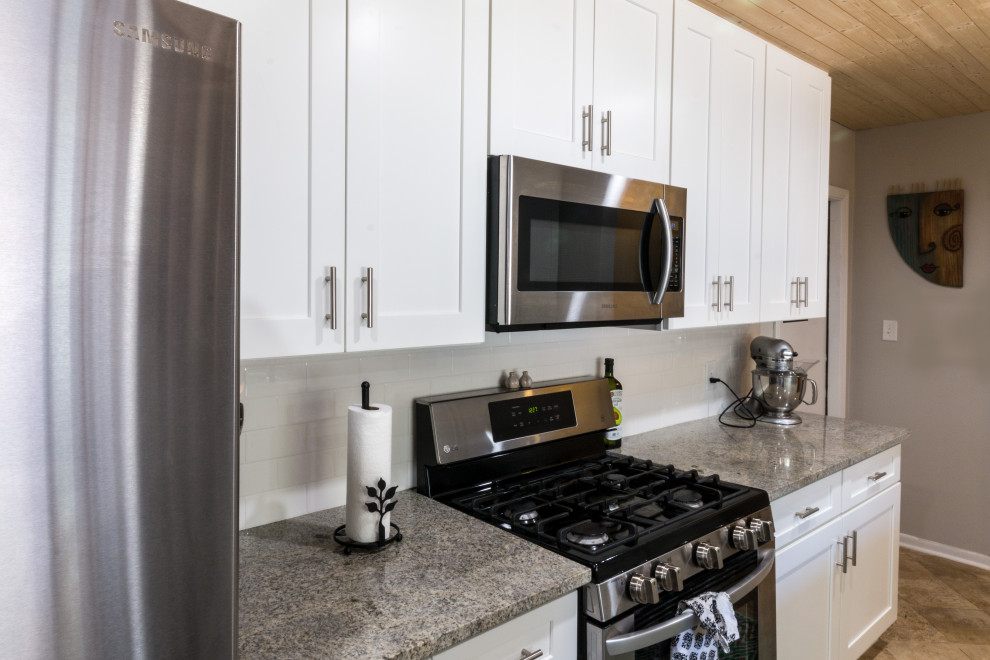 Eat-in kitchen - small transitional cement tile floor and brown floor eat-in kitchen idea with an undermount sink, shaker cabinets, white cabinets, granite countertops, white backsplash, cement tile backsplash, stainless steel appliances, a peninsula and white countertops