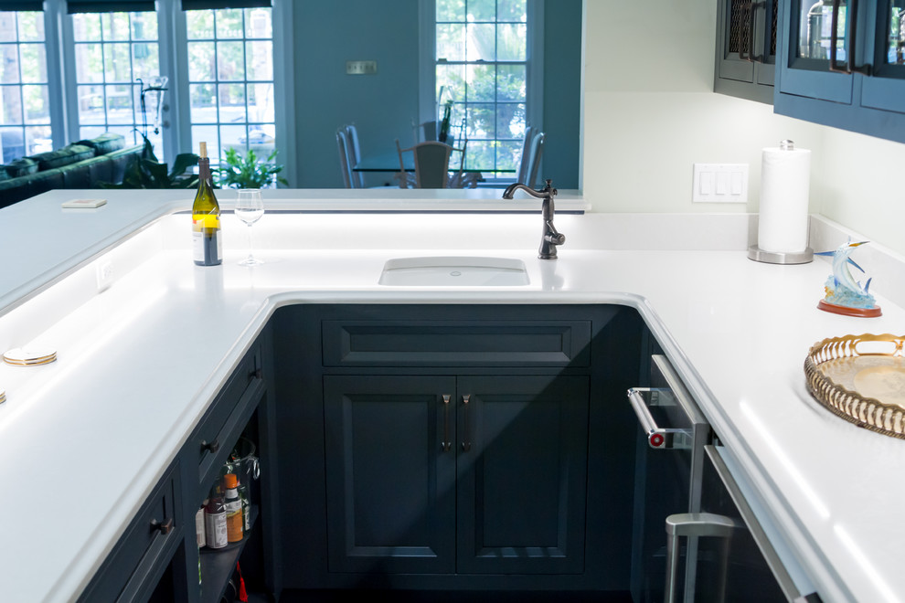 Photo of a traditional home bar in Other with recessed-panel cabinets, blue cabinets, quartz benchtops, white splashback, ceramic floors, grey floor and white benchtop.