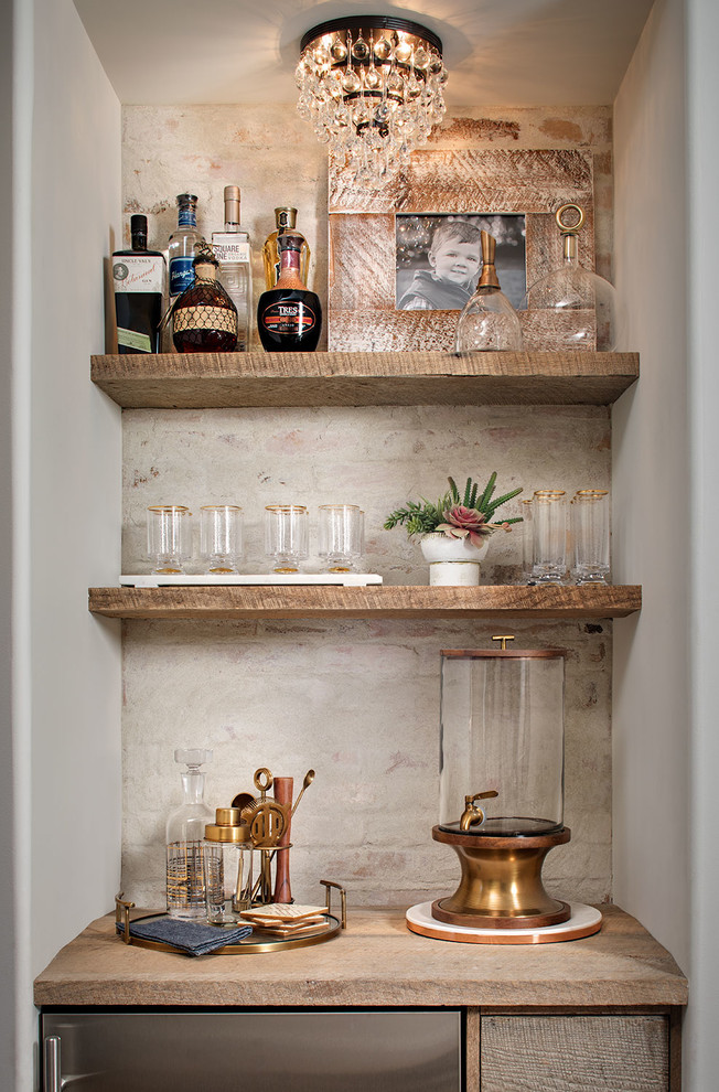 Inspiration for a small country single-wall wet bar in San Diego with recessed-panel cabinets, distressed cabinets, wood benchtops, white splashback and brick splashback.