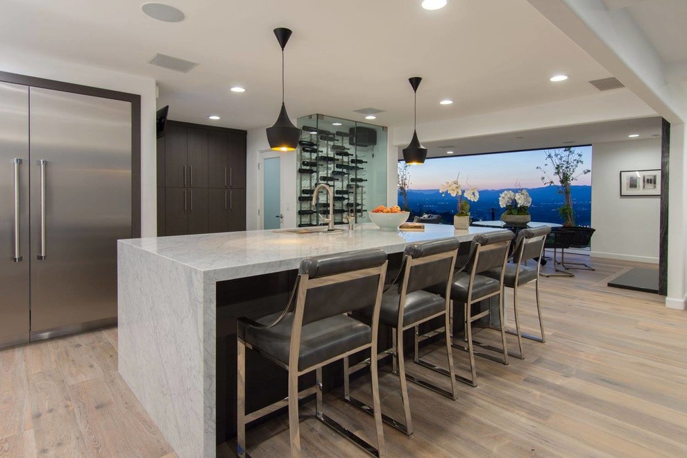 Inspiration for a mid-sized contemporary eat-in kitchen in Los Angeles with an undermount sink, flat-panel cabinets, dark wood cabinets, marble benchtops, stainless steel appliances, with island, light hardwood floors and beige floor.