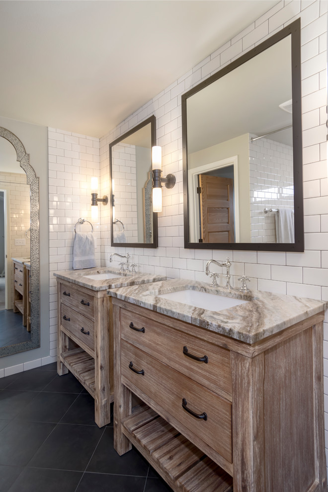 This is an example of a mid-sized mediterranean master wet room bathroom in Seattle with furniture-like cabinets, distressed cabinets, a claw-foot tub, a one-piece toilet, white tile, ceramic tile, grey walls, porcelain floors, an undermount sink, quartzite benchtops, black floor and a shower curtain.
