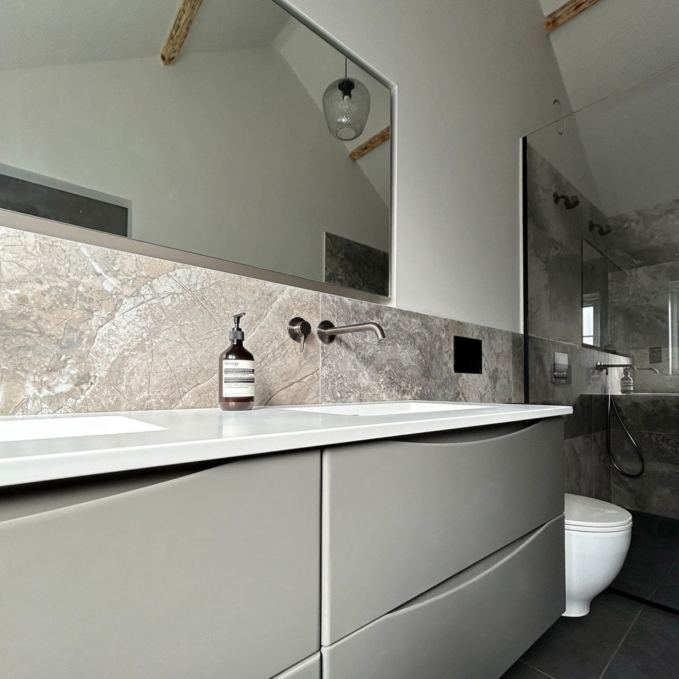 На фото: большая главная ванная комната в современном стиле с плоскими фасадами, серыми фасадами, двойным душем, инсталляцией, коричневой плиткой, керамогранитной плиткой, белыми стенами, полом из керамической плитки, врезной раковиной, столешницей из искусственного кварца, черным полом, открытым душем, белой столешницей, тумбой под две раковины, подвесной тумбой и балками на потолке с