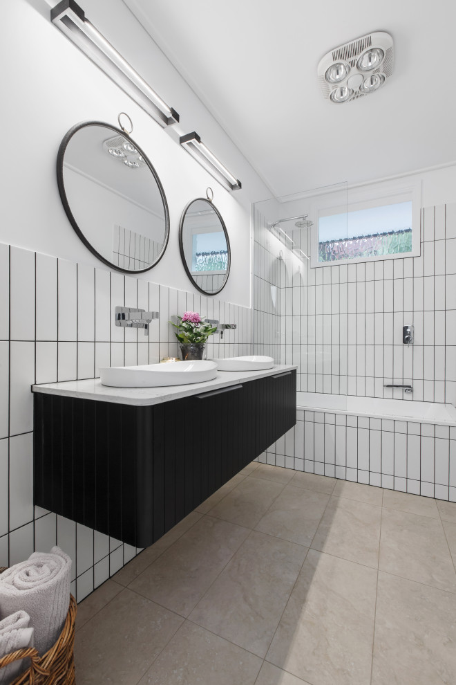 Inspiration for a mid-sized eclectic bathroom in Melbourne with black cabinets, a shower/bathtub combo, white tile, white walls, a drop-in sink, a double vanity and a floating vanity.