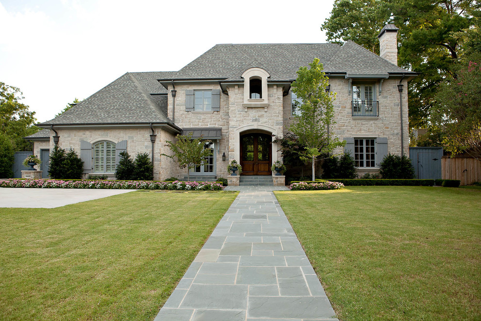 Inspiration for a large traditional front yard driveway in Dallas with natural stone pavers.