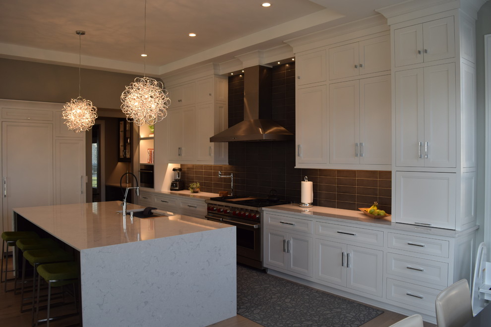 Example of a large transitional l-shaped light wood floor and multicolored floor eat-in kitchen design in Chicago with beaded inset cabinets, white cabinets, quartz countertops, black backsplash, ceramic backsplash, stainless steel appliances and an island
