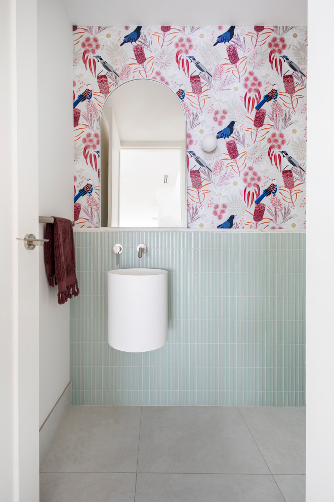 Small contemporary powder room in Canberra - Queanbeyan with white cabinets, a one-piece toilet, blue tile, ceramic tile, white walls, cement tiles, a wall-mount sink, engineered quartz benchtops, grey floor, white benchtops, a floating vanity and wallpaper.