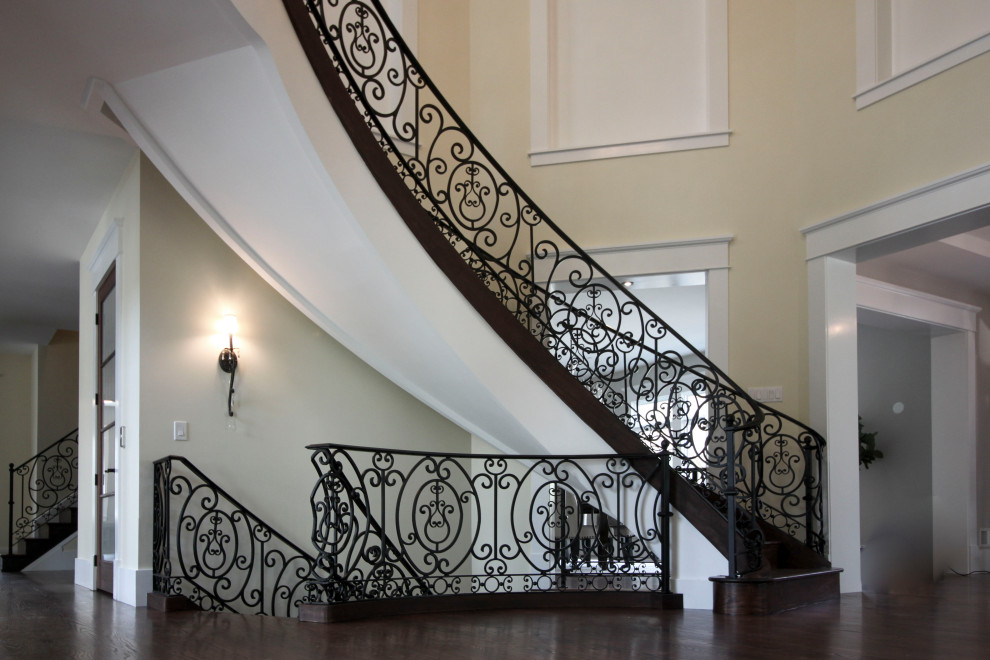Inspiration for an expansive transitional wood curved staircase in DC Metro with wood risers and metal railing.