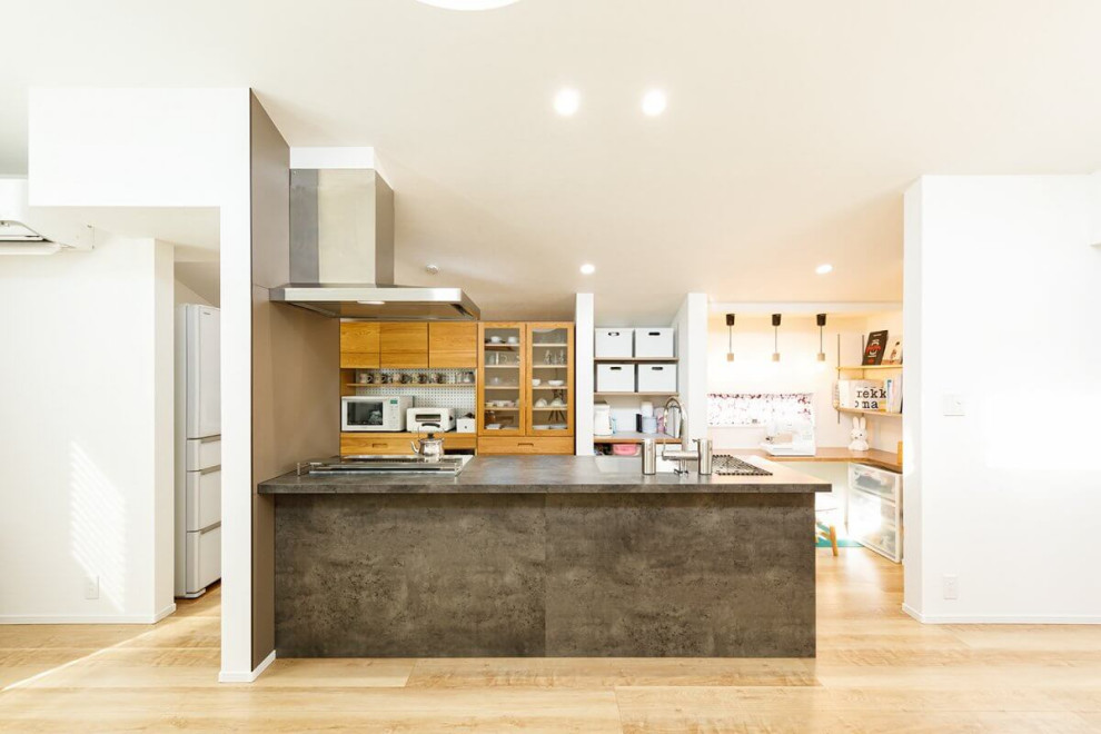 Cette photo montre une cuisine ouverte linéaire industrielle en bois brun de taille moyenne avec plan de travail en marbre, parquet clair, îlot, un sol beige, un plan de travail gris et un plafond en papier peint.
