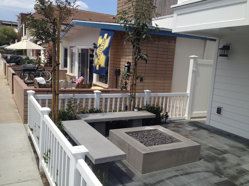 Example of a mid-sized transitional courtyard stamped concrete patio design in Orange County with a fire pit and no cover