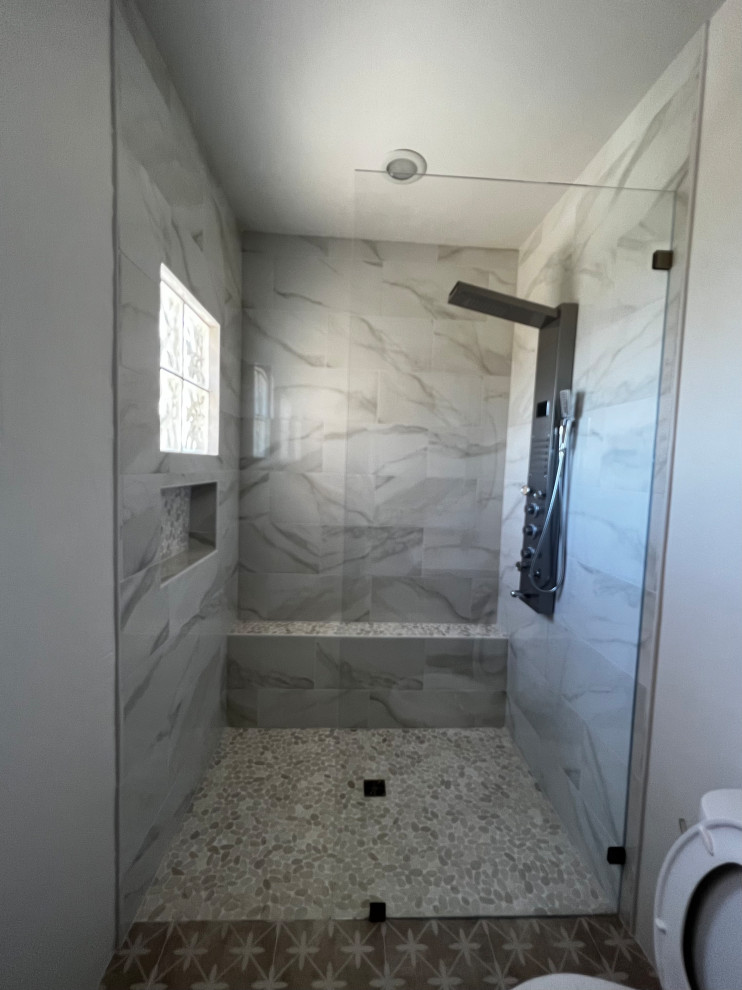 Réalisation d'une salle d'eau minimaliste de taille moyenne avec un espace douche bain, WC séparés, un carrelage multicolore, un mur blanc, un sol en galet, un sol multicolore, aucune cabine, un banc de douche et un plafond voûté.
