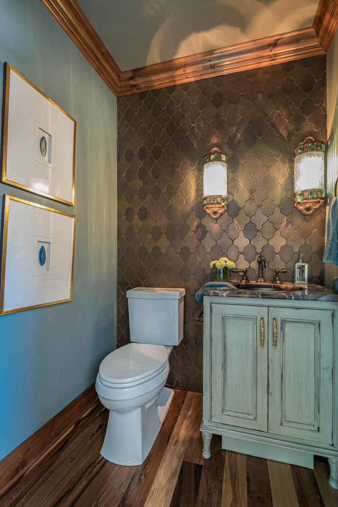This is an example of a large transitional powder room in Milwaukee with furniture-like cabinets, blue cabinets, a two-piece toilet, gray tile, cement tile, green walls, marble floors, an undermount sink, marble benchtops, white floor, blue benchtops and a built-in vanity.