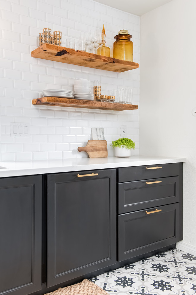 Inspiration for a mid-sized contemporary u-shaped separate kitchen in Los Angeles with an undermount sink, shaker cabinets, black cabinets, quartz benchtops, white splashback, subway tile splashback, stainless steel appliances, porcelain floors, no island and white floor.