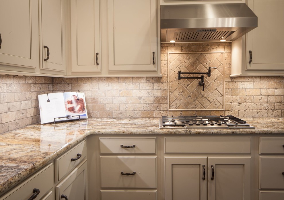 Example of a mid-sized transitional u-shaped dark wood floor and brown floor eat-in kitchen design with a farmhouse sink, recessed-panel cabinets, white cabinets, granite countertops, beige backsplash, ceramic backsplash, stainless steel appliances and an island