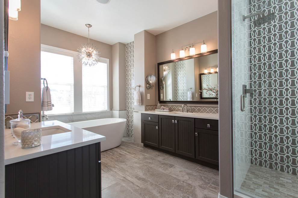 Inspiration for a large transitional master bathroom in Denver with beaded inset cabinets, brown cabinets, a freestanding tub, an alcove shower, a one-piece toilet, beige tile, glass tile, beige walls, ceramic floors, an undermount sink, engineered quartz benchtops, beige floor, a hinged shower door and white benchtops.