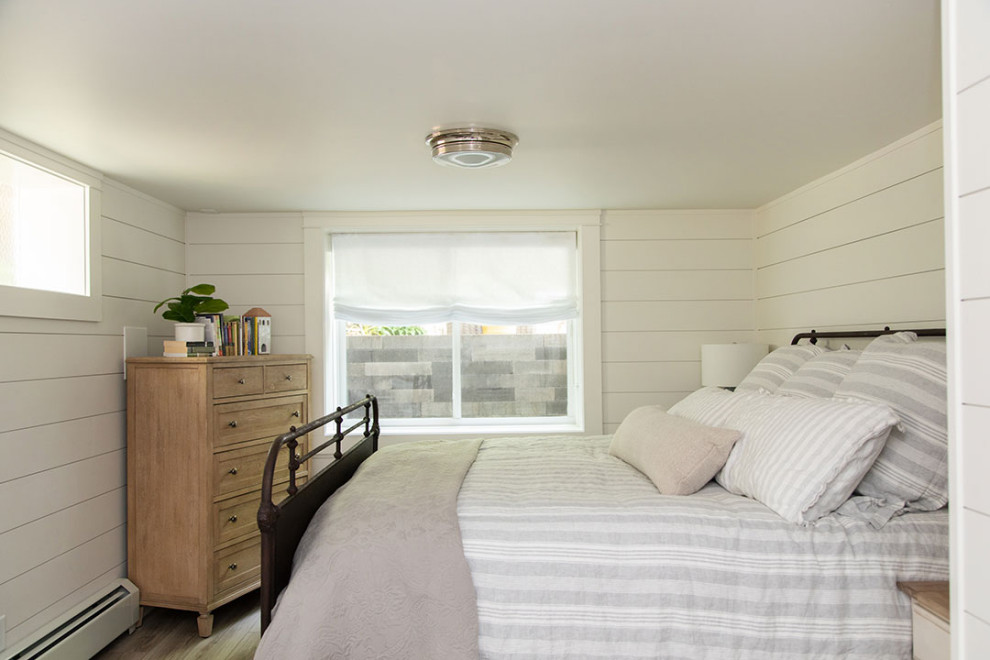 Esempio di una camera degli ospiti stile americano di medie dimensioni con pareti bianche, pavimento in vinile, pareti in perlinato e pavimento beige