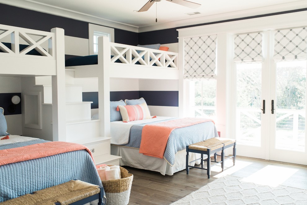Beach style bedroom in Charleston with blue walls, medium hardwood floors and brown floor.