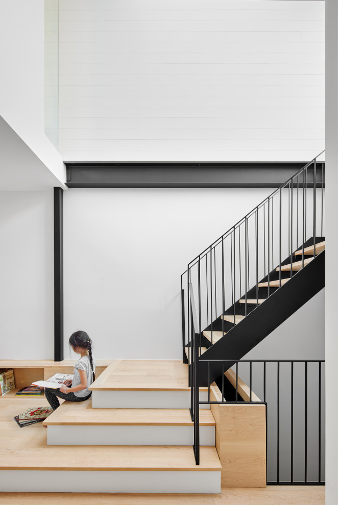 Mid-sized modern wood staircase in Montreal with metal railing.