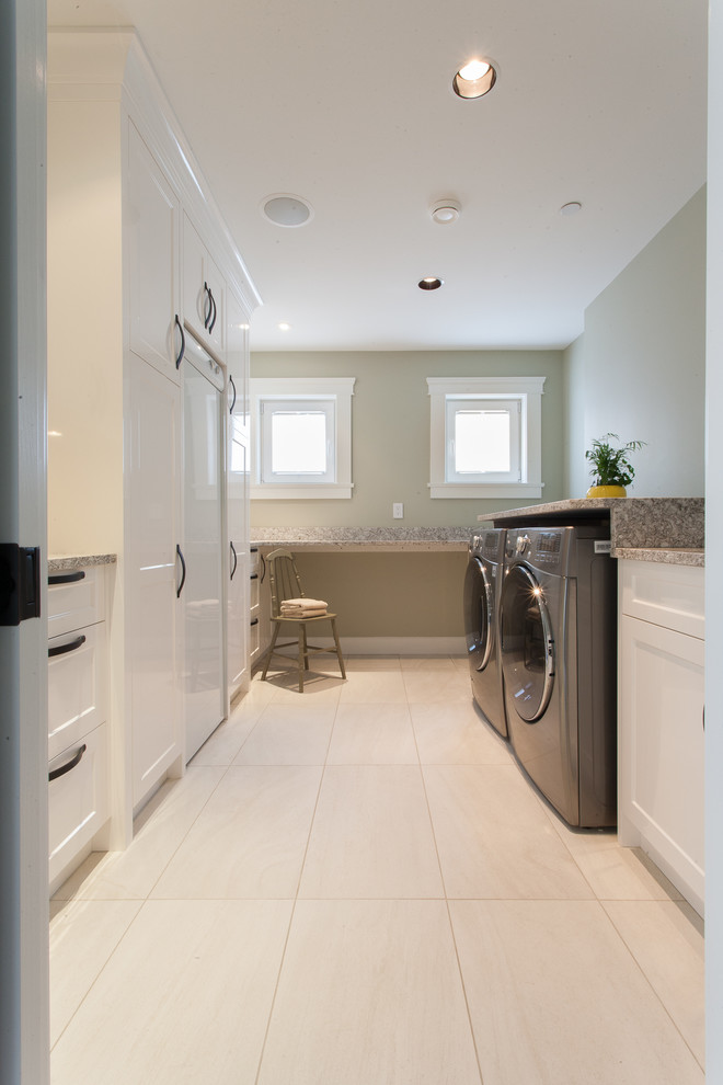 This is an example of a transitional laundry room in Vancouver with white cabinets and white floor.