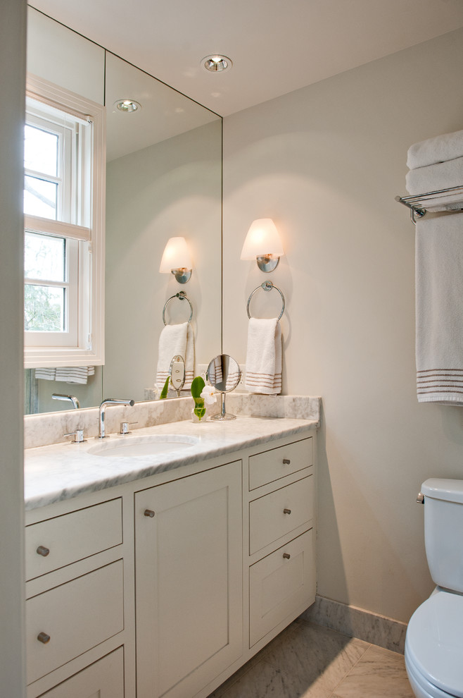 Large transitional 3/4 bathroom in Nashville with an undermount sink, shaker cabinets, white cabinets, marble benchtops, a shower/bathtub combo, a one-piece toilet, white tile, white walls and marble floors.